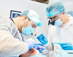 dental surgeons inserting dental implant