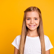 Girl smiling after seeing children’s dentist