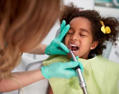 little girl getting her teeth cleaned by a hygienist