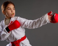 little girl wearing a mouthguard and a karate uniform