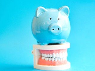 blue piggy bank on top of dentures