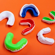 Series of mouthguards resting on orange background