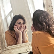 Woman looking in mirror at her smile
