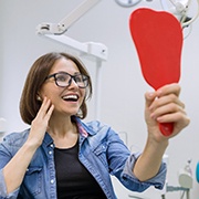 Young woman admiring her new dental implants in Flint