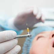 A dentist holds a dental implant in preparation for surgical placement in Oklahoma City