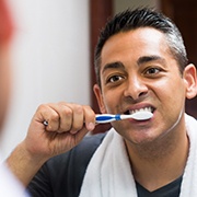 Man brushing his dental implants in Oklahoma City