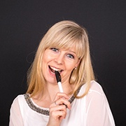 Woman with dental implants in Oklahoma City chewing on a pen