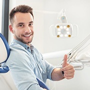 young man giving thumbs up in the dentist’s chair