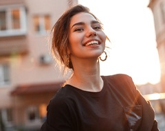 person smiling and standing in a street
