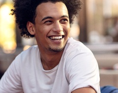 person smiling and sitting in a chair