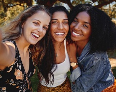 friends smiling and taking a walk in a park together