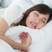 A woman sleeping and clenching her teeth.