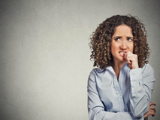 Woman nervously biting her thumbnail