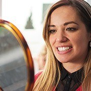 Woman looking at smile in mirror