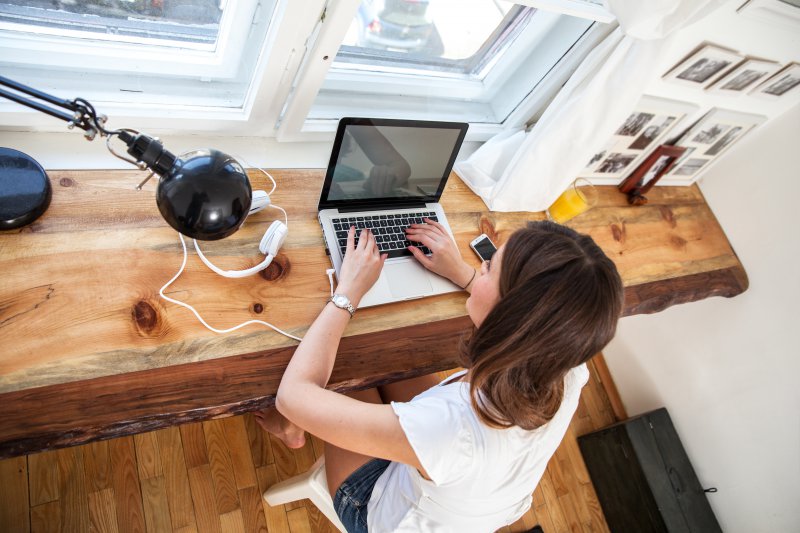 A woman web searching for a dentist in her home.